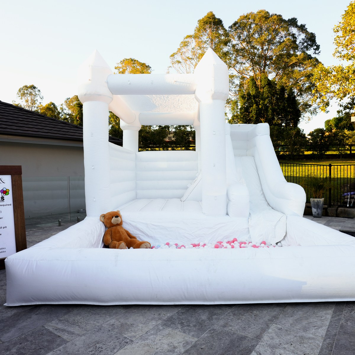 White jumping castle filled with pastel ball pit balls
